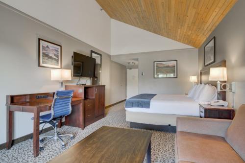 a hotel room with a bed and a desk at Whitefish Riverfront Hotel in Whitefish