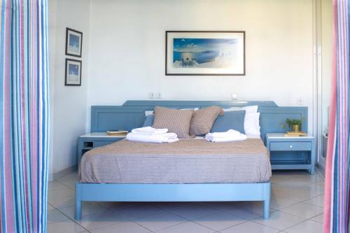 a bedroom with a blue bed with two towels on it at Blue Calm in Daratso