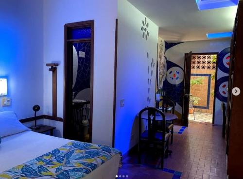 a bedroom with a bed and a table and chairs at Hotel Casa Santa Monica Norte in Cali