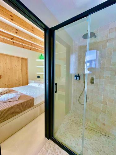 a glass shower in a bedroom with a bed at MIMARE Dénia in Denia