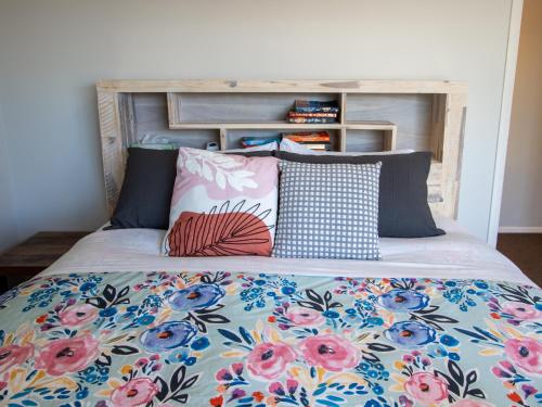 a bed with colorful pillows on top of it at Tasman Haven - Motueka Holiday Home in Motueka
