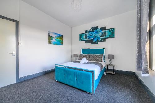 a bedroom with a blue bed in a white room at -RB27A- For your relaxed & Cosy stay,Free Parking in Leeds