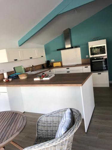 - une cuisine avec un comptoir et des chaises dans l'établissement Maison 6 à 8 pers au bord du Lac de Biscarrosse, à Biscarrosse