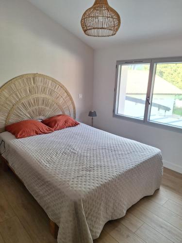 une chambre avec un grand lit blanc avec des oreillers rouges dans l'établissement Maison 6 à 8 pers au bord du Lac de Biscarrosse, à Biscarrosse