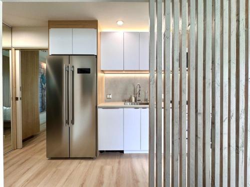 a kitchen with a stainless steel refrigerator and white cabinets at Titus Retreat in San Diego