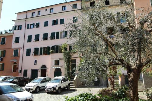 a building with cars parked in front of it at La casa del pittore con climatizzatore Pieve di Teco centro in Pieve di Teco