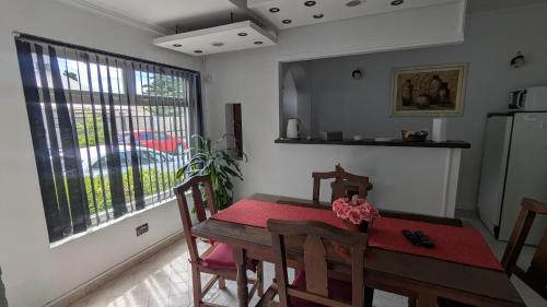 a kitchen with a dining room table and a large window at Tu lugar en Rada Tilly in Rada Tilly