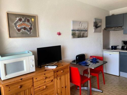 - une cuisine avec un bureau, un four micro-ondes et une table avec des chaises dans l'établissement Résidence Port Soleil Bâtiment B2 - Studio 4 pers.- Résidence Port Soleil MAE-4394, au Cap d'Agde