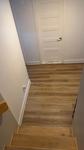 pasillo con puerta blanca y suelo de madera en Cozy Terrebonne, en Terrebonne