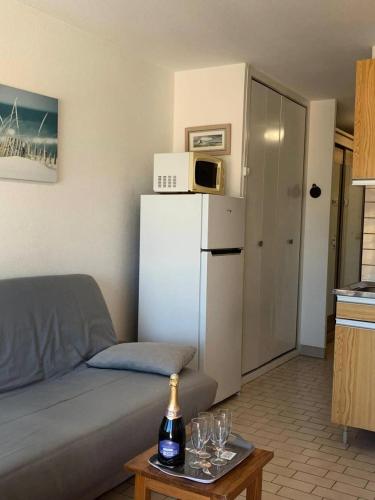 - un salon avec un canapé et un réfrigérateur blanc dans l'établissement Résidence Port Soleil Bâtiment B3 - Studio cabine 4 pers Résidence Port Soleil MAE-3004, au Cap d'Agde