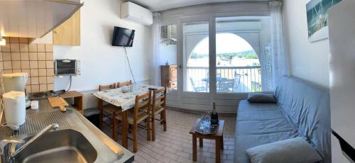 une cuisine et un salon avec un canapé et une table dans l'établissement Résidence Port Soleil Bâtiment B3 - Studio cabine 4 pers Résidence Port Soleil MAE-3004, au Cap d'Agde