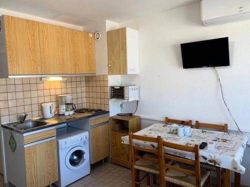 une petite cuisine avec une table et un micro-ondes dans l'établissement Résidence Port Soleil Bâtiment B3 - Studio cabine 4 pers Résidence Port Soleil MAE-3004, au Cap d'Agde