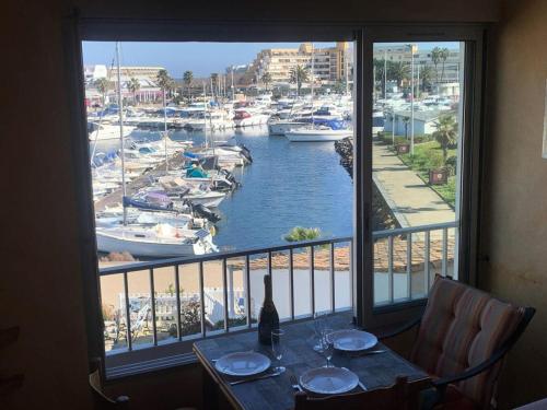 Cette chambre avec une table et une fenêtre offre une vue sur le port de plaisance. dans l'établissement Résidence Port Soleil Bâtiment B1 - Duplex T2 4 pers. - Résidence Port Soleil MAE-3224, au Cap d'Agde