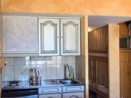 une cuisine avec des armoires blanches et un évier dans l'établissement Résidence Port Soleil Bâtiment B1 - Duplex T2 4 pers. - Résidence Port Soleil MAE-3224, au Cap d'Agde