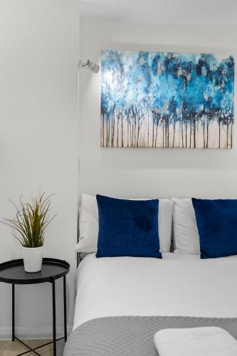 a bedroom with a bed and a painting on the wall at Substantial 5 bedroom townhouse with disabled access apartment, private off road parking space with EV point from 15th April 26, jaccuzi bath, Netflix and Wifi, near Argyle, boutique shops eateries and pubs in Plymouth