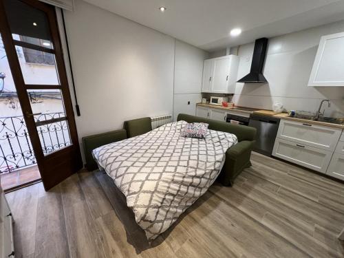 a bedroom with a bed and a kitchen at Bermudo III Plaza Mayor de León in León