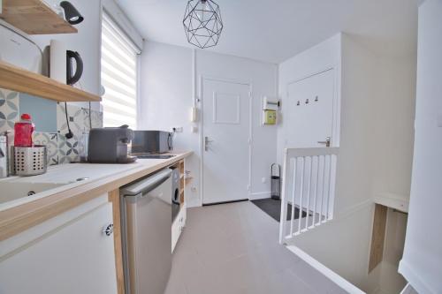 - une cuisine avec des murs blancs et un comptoir dans l'établissement The secret cave, à Reims