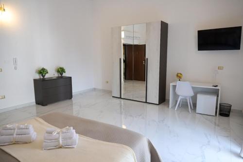 Un dormitorio con una cama, un escritorio y un espejo. en IL GIGLIO b&b, en Recale