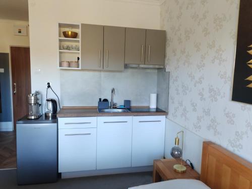 a kitchen with white cabinets and a sink at Apartmán Stella, Vysoké Tatry in Tatranska Strba