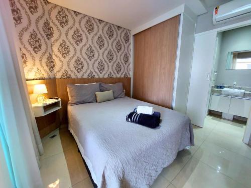 a bedroom with a bed with a black bag on it at BookSantos Estanconfor 1503 -Charmoso e Próximo à Praia! in Santos