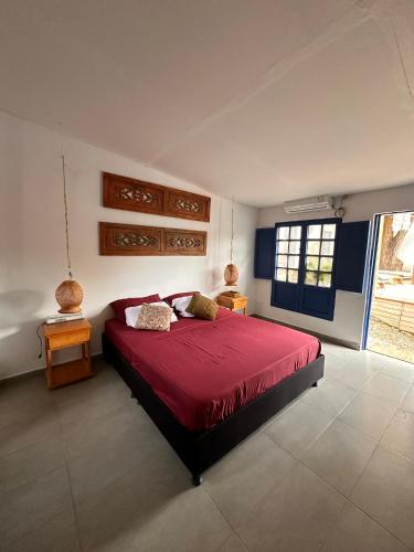 a bedroom with a large red bed with two tables at HOTEL RENASCI PALOMINO in Palomino