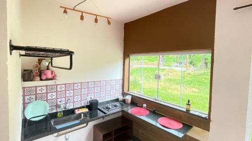 una cocina con fregadero y ventana en Rubi, en São Pedro