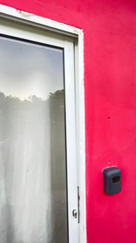 a red wall with a window in front of it at Chácara Itaqueri Rubi in São Pedro