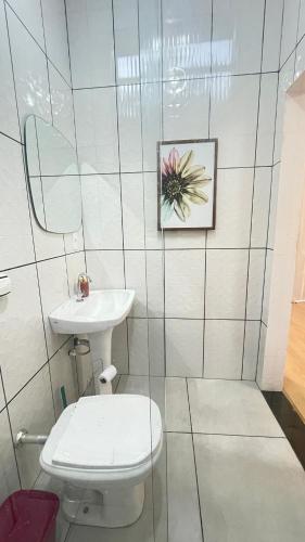 a bathroom with a toilet and a sink at Chácara Itaqueri Rubi in São Pedro