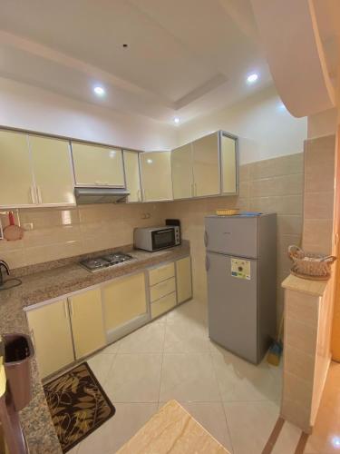 a kitchen with white cabinets and a refrigerator at Dar Assalam in Oualidia