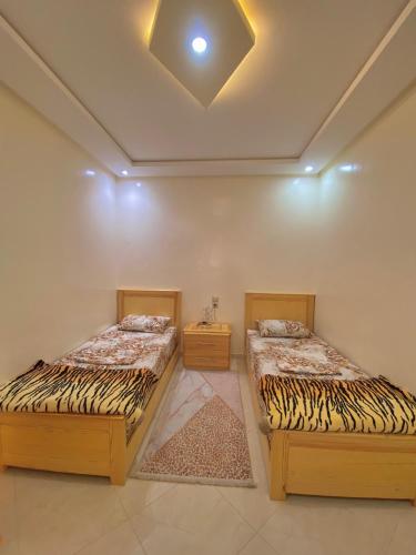 two twin beds in a room with a ceiling at Dar Assalam in Oualidia