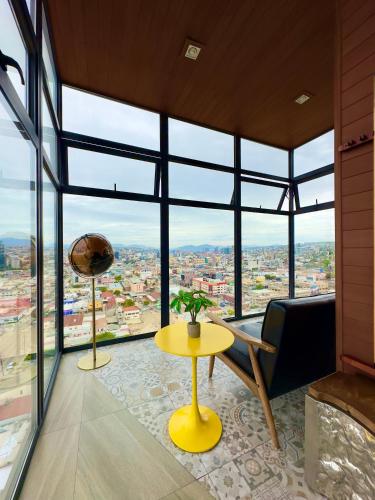 a living room with a yellow table and glass windows at Downtown Tijuana 1 BR Ave Revolucion Suite 1st floor in Tijuana