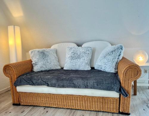 a wicker chair with pillows on it in a room at Küstenkoje Red Balkon und Hund willkommen in Prerow