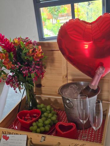 a table with a vase and flowers and wine glasses at Confraria da Prata Flats in Pirenópolis