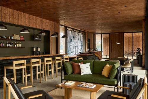 a living room with a green couch and a bar at AutoCamp Sequoia in Three Rivers