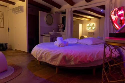 une chambre avec un lit avec un animal en peluche dessus dans l'établissement Love Room l'Eden Secret, à Grans