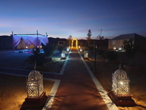 a lit up street with a building in the background at Khadija Desert Camp in Merzouga