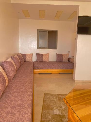 a large couch in a room with a television at Dar Assalam in Oualidia