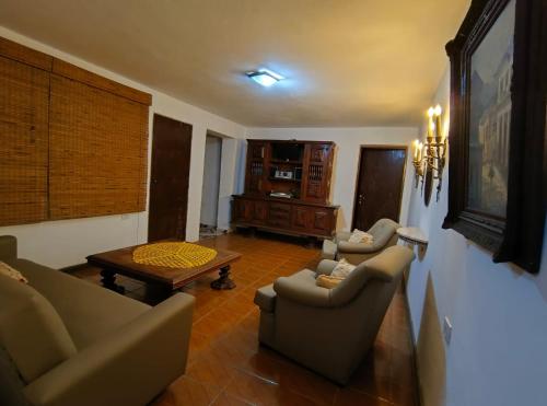 a living room with two couches and a table at Pousada Casa Cristal Mineiro in Santo Antônio do Pinhal