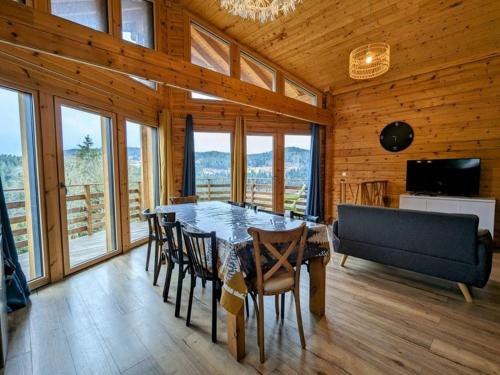une salle à manger avec une table, des chaises et un canapé dans l'établissement Chalet L 'instant Géromois, à Gérardmer