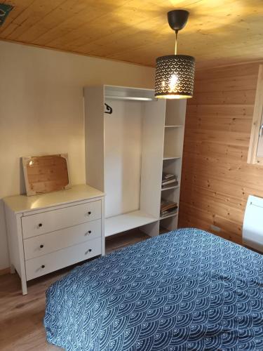 une chambre avec un lit et une commode dans l'établissement Chalet L 'instant Géromois, à Gérardmer