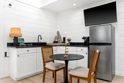 a kitchen with a table and a refrigerator at Ares Treehouse Romantic Hottub Fredericksburg EV in Fredericksburg
