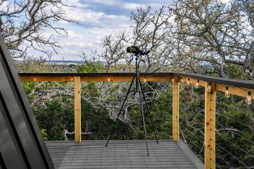 a camera on a tripod on a deck at Ares Treehouse Romantic Hottub Fredericksburg EV in Fredericksburg
