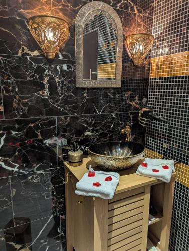 une salle de bain avec un lavabo et un miroir dans l'établissement 1000 et une Nuit, à La Boissière-de-Montaigu