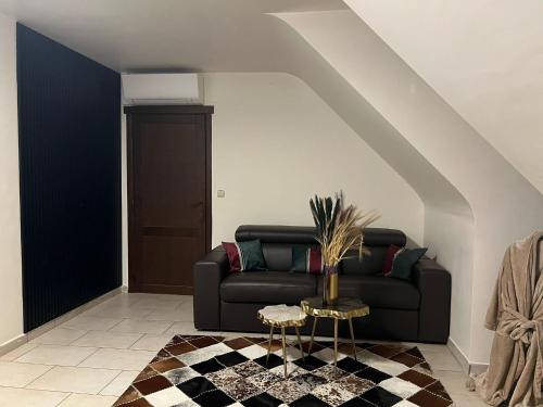 a living room with a black couch and a table at Villa op de hoek Rooms in Aalst