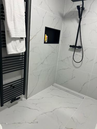a bathroom with a shower with white marble tiles at Villa op de hoek Rooms in Aalst