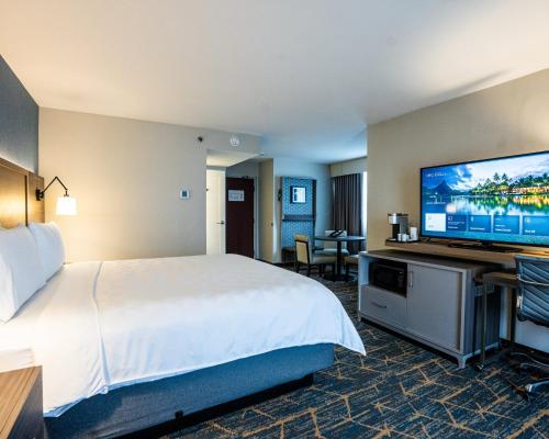 a hotel room with a bed and a flat screen tv at Holiday Inn Kingston - Waterfront by IHG in Kingston