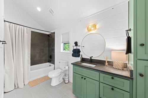 a bathroom with a sink and a toilet and a mirror at Apate Treehouse Lux Hot tub Fredericksburg EV BBQ in Fredericksburg