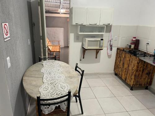 a kitchen with a table with chairs and a microwave at Flat J&C próx Praia da graciosa e UFT e Unitins in Palmas
