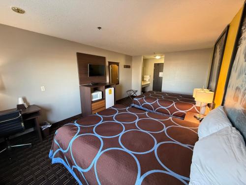 a hotel room with a large bed and a flat screen tv at Super 8 by Wyndham Reedsburg in Reedsburg
