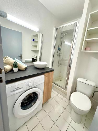 une salle de bain avec machine à laver et toilettes dans l'établissement Cocon marin - Parking - Proche mer, à La Grande Motte